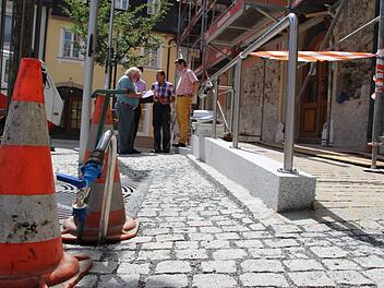 Die Mauertrockenlegung und der barrierefreie Zugang (rechts) zum Rathaus sind fast fertig, jetzt folgt die Fassadensanierung. Ingenieur Hans Spindler, Verwaltungsleiter Florian Puff, Handwerksmeister Paul Spindler und Bürgermeister Roland Wolfrum (von links) besprechen beim Ortstermin weitere Details. Foto: Matthias Beetz