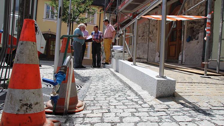 Die Mauertrockenlegung und der barrierefreie Zugang (rechts) zum Rathaus sind fast fertig, jetzt folgt die Fassadensanierung. Ingenieur Hans Spindler, Verwaltungsleiter Florian Puff, Handwerksmeister Paul Spindler und Bürgermeister Roland Wolfrum (von links) besprechen beim Ortstermin weitere Details. Foto: Matthias Beetz