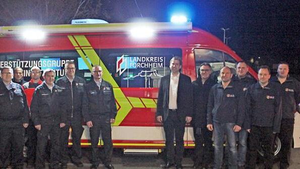 Landrat Hermann Ulm sowie der Kreisbrandrat, die Einsatzleiter und die Unterst&uuml;tzungsgruppe &uuml;bernehmen den neuen Einsatzleitwagen. Foto: Landratsamt Forchheim