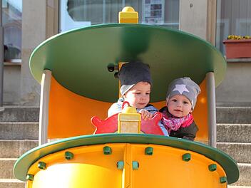 Am Steuer eines Spielgeräts, das auf dem Marktplatz aufgebaut ist: Brian Jordan aus Weichersbach geht mit seiner Mama manchmal Einkaufen in Bad Brückenau, hauptsächlich im Fachmarktzentrum.    Mayra Wähner aus Zeitlofs besucht gerne Oma und Opa.  Foto:  Ulrike Müller
