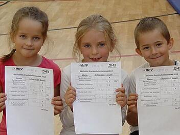Kinga Nowak (Handballerin), Linda Kopp (kegelt, turnt und schwimmt) und Leon Kammerer (aktiver Fußballer) präsentieren stolz ihre Laufzettel. Foto: Brigitta Kempe-Wolf