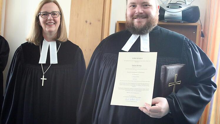"Pfarrer auf Lebenszeit" darf sich Tobias Knötig seit 1. Januar 2018 nennen. Am Sonntag wurde der Heilgersdorfer Geistliche von Dekanin Stefanie Ott-Frühwald (Michelau, links) während eines Festgottesdienstes in der Kirche "Zu unserer lieben Frauen" in seinem Amt installiert. Die Urkunde beweist, dass die Knötig übertragene Dienststelle die gleiche bleibt: das Pfarramt in Heilgersdorf. Foto: Bettina Knauth