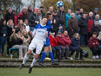 Vor zahlreichen Zuschauern gehen der Mitwitzer Johannes Schmidt (wei&szlig;es Trikot) und der M&ouml;nchr&ouml;dener Torsch&uuml;tze Niklas Ehrlich zum Kopfball.  Foto: Heinrich Wei&szlig;