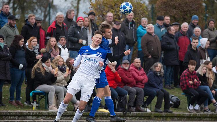 Vor zahlreichen Zuschauern gehen der Mitwitzer Johannes Schmidt (wei&szlig;es Trikot) und der M&ouml;nchr&ouml;dener Torsch&uuml;tze Niklas Ehrlich zum Kopfball.  Foto: Heinrich Wei&szlig;