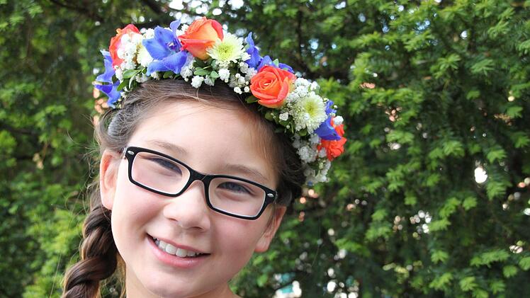 Die neunjährige Carolina Wilmers aus der Max-Hundt-Schule trägt ihren Blumenkranz mit Stolz. Foto: Stephan Stöckel