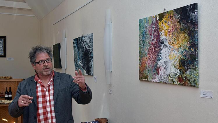 Bei der Vernissage im Weinhaus Schaffner erläuterte der Maler und Objekt-Künstler Hannes Betz seine Arbeiten. Im Bild eines seiner abstrakten Gemälde mit dem Titel "Universum".