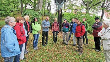 Im Hindenburgpark sprach Pater Markus (6. von links) zu den Wallfahrern über das umstrittene Kunstwerk des Bad Neustädter Künstlers Jürgen Lacher. Außerdem im Bild: Pater Rudolf (2. von rechts). Foto: Dieter Britz