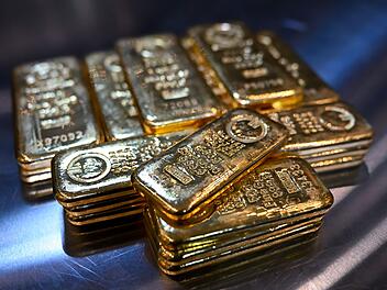 Goldbarren liegen in einem Tresor auf einem Tisch