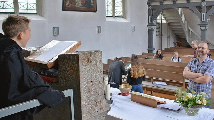 Predigen, sich in den liturgischen Gewändern präsentieren, das Kreuz tragen oder in der Bibel lesen. All das konnte man beim Kirchenentdeckertag in der evangelischen Kirche Bad Königshofen. Foto: Hanns Friedrich