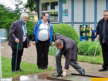 Bürgermeister Wolfgang Back (l.) schaffte mit zwei, Pfarrer Michael Kubatko (Mitte) mit drei Schlägen den Ball ins Loch; Zuschauer waren Jeanette Humbek-Hönicke, Vorsitzende des Minigolfclubs "Stahlquelle" und Ingo Graf von Mainberg, Lehrwart im Bayerischen Minigolfsport-Verband. Fotos: Sigismund von Dobschütz
