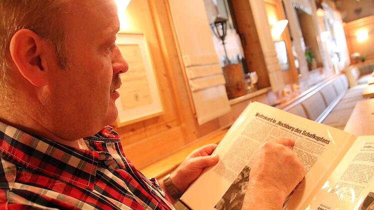 Andreas Pfarrdrescher mit einem der beiden Alben, in dem die Zeitungsartikel über das Dauerschafkopfturnier gesammelt sind.Matthias Einwag