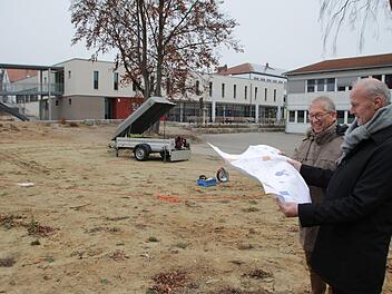 Bürgermeister  Brehm (rechts) und Rektor Ulbrich freuen sich auf dem Gelände des künftigen Pausenhofs über die  bevorstehende Umsetzung der Pläne.  Foto: Andreas Dorsch