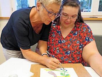 Durch das Betupfen mit Wasser beginnen die Farben der Früchte zu leuchten; Elfriede Dauer (links) mit Daniela Gäbelein Foto: Monika Schütz