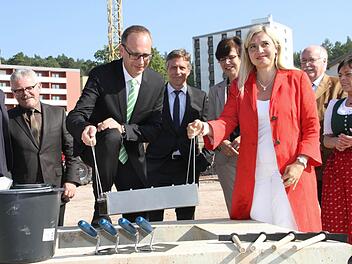 Als Andenken: Landrat Christian Meißner und Bayerns Gesundheitsministerin Melanie Huml bringen eine Kassette mit Zeitdokumenten in den Grundstein ein. Foto: Gerda Völk