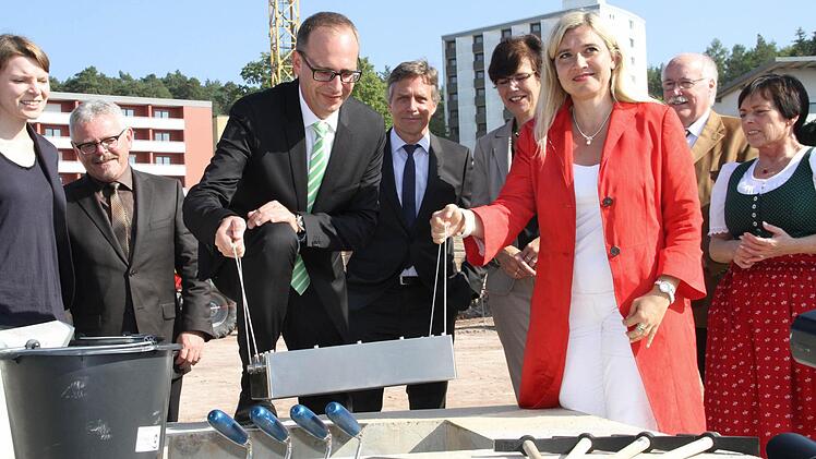 Als Andenken: Landrat Christian Meißner und Bayerns Gesundheitsministerin Melanie Huml bringen eine Kassette mit Zeitdokumenten in den Grundstein ein. Foto: Gerda Völk