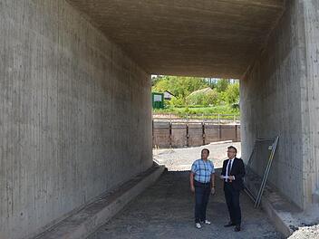 Die fertiggestellte sanierte Bahnüberführung ist nicht das Problem der Maxschachtstraße, sondern das dahinter vom Hang  austretende Schichtenwasser, erklären Bauamtsleiter Günter Hempfling (links) und Bürgermeister Rainer Detsch vor Ort.  K.- H. Hofmann