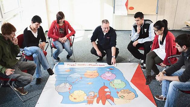 Auf spielerische Weise erkl&auml;rt der Erste-Hilfe-Trainer den Kursteilnehmern die lebensrettenden Griffe. Frank Schemmann/Johanniter