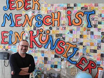 Karsten Raimann vor seinem Beuys-Credo, das an der Wand des Kunstraums prangt.  Foto: Karina Brock