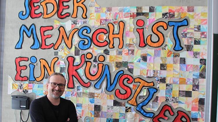 Karsten Raimann vor seinem Beuys-Credo, das an der Wand des Kunstraums prangt.  Foto: Karina Brock
