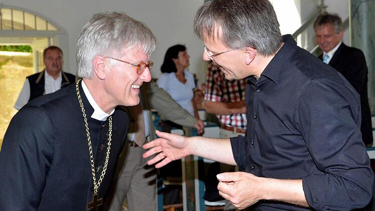 Der Landesbischof begrüßt Chorleiter Thomas Grünke bei der Generalprobe für das Konzert in der St. Johannes-Kirche.