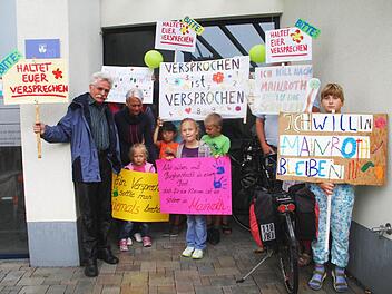 Standen im Regen: Die Eltern und Kinder, die für den Erhalt des Schulstandorts in Mainroth kämpfen, demonstrierten vor dem Rathaus. Foto: Gerda Völk
