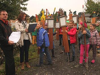 In einem Zug trugen die Schüler ihre Tafeln von der Schule zur Streuobstwiese. Peter Kirchner und Antje Schorn (von links) warben dafür, den Streuobstlehrpfad immer wieder mal zu besuchen. Foto: Günther Geiling