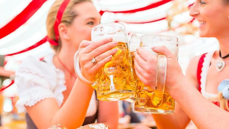 Friends drinking together Bavarian beer in national costume or Dirndl on Oktoberfest Freundinnen trinken zusammen Bier im Bayrischen Dirndl auf Volksfest  von Festzelt, Zelt, Bier