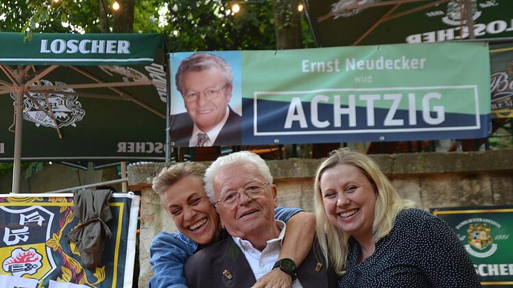 Tochter Sonja und Enkelin Sabrina umherzen den Jubilar. Sie haben auch ein Schild zur Feier angefertigt.  Fotos: Bernhard Panzer