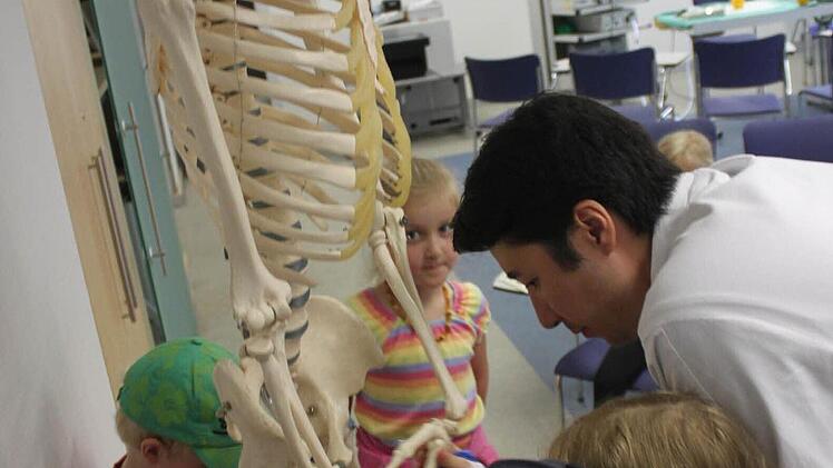 An einem Skelett erklärt Assistenzarzt Dr. Sebastian Krinner den Kleinen, wie der menschliche Körper aufgebaut ist.
