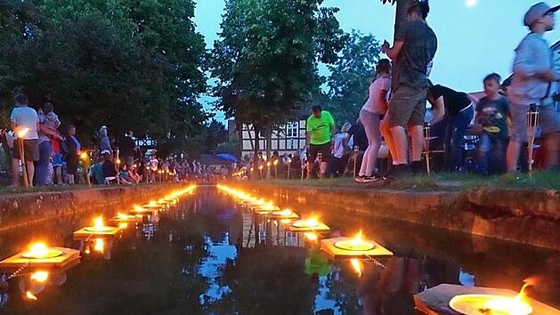 Eine wundervolle Illumination: Die Lichter und schwimmenden Feuerschalen spiegeln sich im Wasser des M&uuml;hlbaches. Fotos: Peter B&auml;umel