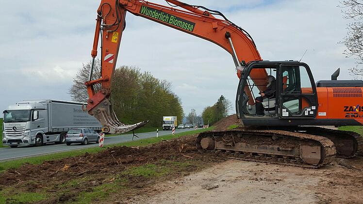 Ein Bagger ist an der Böschung im Einsatz.