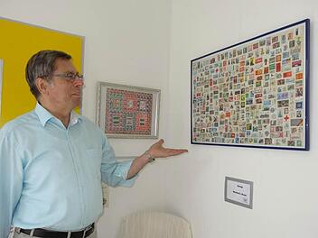 Kleinkunst: Manfred Hauer präsentiert seine bunten Briefmarkencollagen in der Bischofsheimer Postagentur. Foto: Marion Eckert