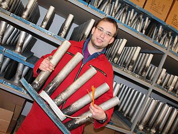 Julian Woesch inmitten eines Arsenals von metallenen Abschussrohren. Foto: Benedikt Borst