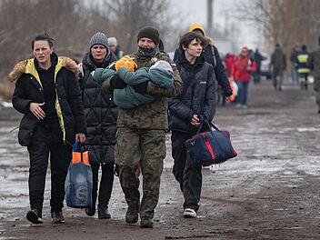 Ein polnischer Soldat trägt ein Kind, während Frauen und Kinder nach ihrer Flucht aus der Ukraine am Grenzübergang in Medyka, Polen, zu einem Zug in Richtung Krakau gehen. Nach Angaben der Vereinten Nationen hat der russische Angriff zwei Millionen Menschen gezwungen, aus der Ukraine zu fliehen.