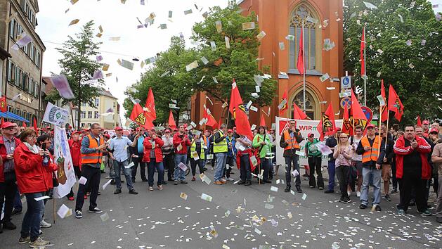 Die Streikenden lassen Spielgeld regnen, um auf ihre Lohnforderung aufmerksam zu machen. Foto: RiegerPress