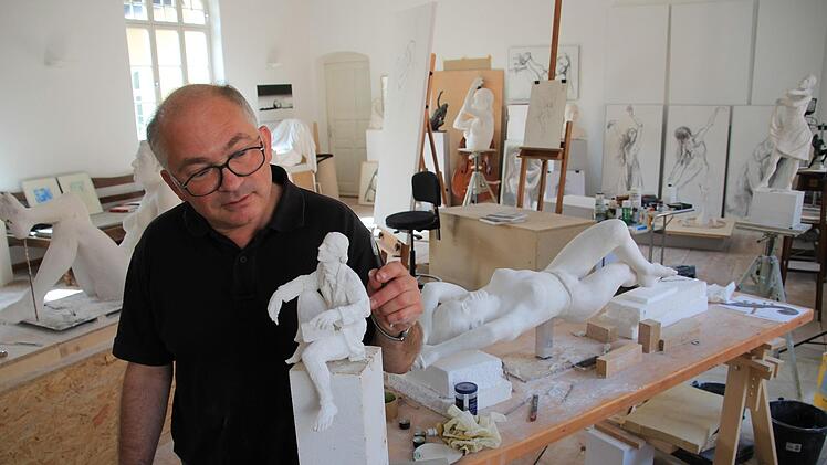 Andreas Krämmer steht in seinem Atelier in Seßlach hinter einem kleinen Modell des Victor-von-Scheffel-Denkmals. Es wird später seinen Platz in der Bad Staffelsteiner Bahnhofstraße finden. Foto: Tobias Kindermann