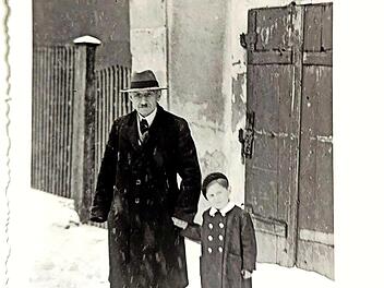 Die Fotografie von etwa 1949 zeigt Albert Schloß vor seinem Wohnhaus in Mühlhausen, zusammen mit dem etwa sechsjährigen Ralf Kriegel, dem Enkel von Frau Preussner, die eine Freundin der Eheleute Schloß gewesen ist.