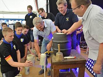 Bürgermeister Ludwig Wahl sticht unter Aufsicht der Vereinsvertreter das erste Fass der Zeckerner Kerwa an.  Foto: Larissa Händel