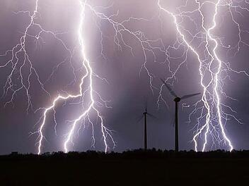 Ein Gewitter &uuml;ber einem Windpark (Symbolfoto): Im Kreis-Umweltausschuss gab es wegen Windkraft ebenfalls ein Donnerwetter. Foto: Bernd M&auml;rz/dpa