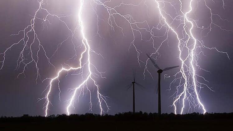 Ein Gewitter &uuml;ber einem Windpark (Symbolfoto): Im Kreis-Umweltausschuss gab es wegen Windkraft ebenfalls ein Donnerwetter. Foto: Bernd M&auml;rz/dpa