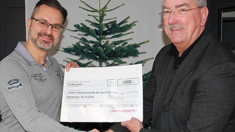 "Uns ist wichtig, dass das Geld hier vor Ort bleibt", sagt Joachim Heinlein vom Ingenieurteam Oberthulba (links). Redaktionsleiter Paul Ziegler freut sich sehr über die großzügige Spende in Höhe von 5000 Euro für die Aktion "Weihnachtshilfe" der Saale-Zeitung. Foto: Carmen Schmitt