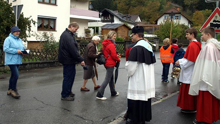 Pfarrer Richard Reis begrüßt die Wallfahrer aus Nurn mit Weihwasser. Links in blau Wallfahrtsführerin Katharina Deuerling. Foto: Susanne Deuerling