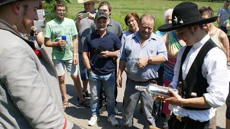 Gute Wünsche und Andenken wurden in die "Flaschenpost" gefüllt, die nach altem Brauch am Ortsschild vergraben wurde. Bei seiner Rückkehr wird sie wieder ausgebuddelt. Fotos: Sabine Weinbeer