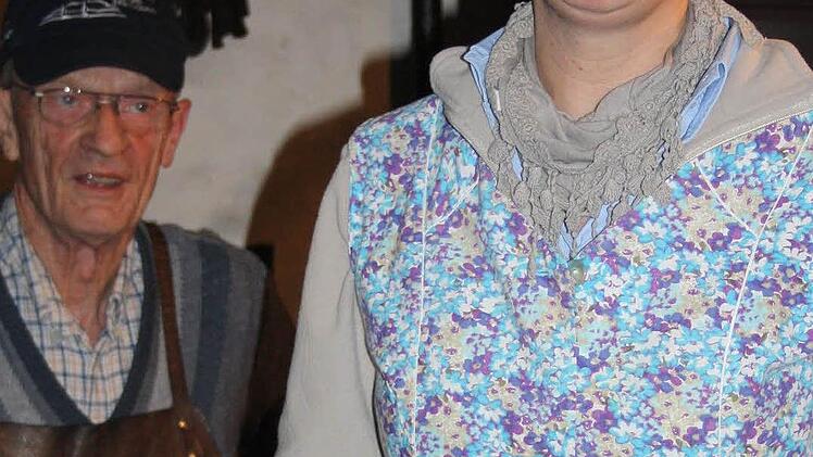Gastgeberin Claudia Ingeduld bei der Begrüßung, stilecht in Kittelschürze - Willi Gruschke hört aufmerksam zu.
