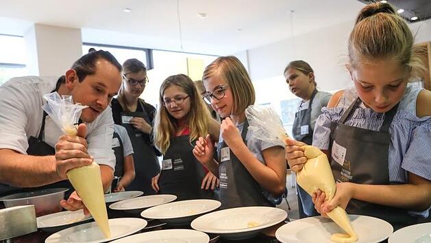 Anrichten wie in der Sternek&uuml;che: Michael Laus zeigt den Kindern, wie's gemacht wird. Fotos: Barbara Herbst