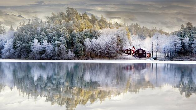 Rural house by a small hill reflected in the water in the early winter L&auml;ndliches Haus in Schweden an einem kleinen H&uuml;gel, das sich im fr&uuml;hen Winter im Wasser spiegelt
