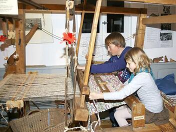 Johanna und ihr Cousin Sebastian erwecken am alten Webstuhl im Heimatmuseum die Geschichte zum Leben. Fotos: Tom Müller