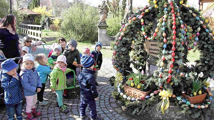 Stolz bestaunten die Kindergartenkinder den Osterbrunnen, zu dem sie auch einige Eier beigetragen haben.  Foto: Richard Sänger