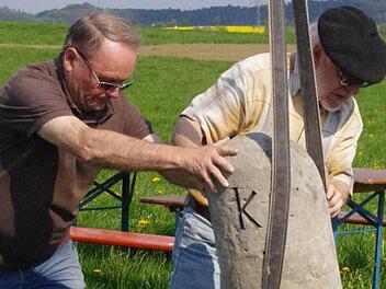 Karl-Heinz Rebhan (l.) und Roland Graf rücken den Grenzstein in die richtige Position. Fotos: Marco Meißner