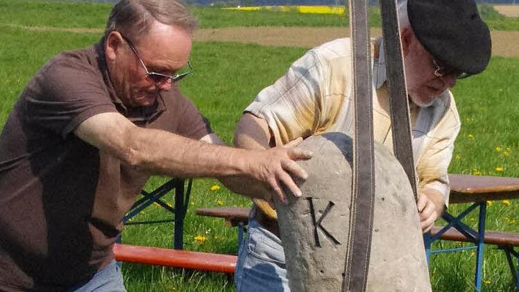 Karl-Heinz Rebhan (l.) und Roland Graf rücken den Grenzstein in die richtige Position. Fotos: Marco Meißner